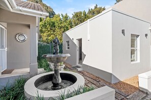 A modern building with a fountain, a clock, and a small window. - Sangrove Residence - Four Bedroom House, Sleeps 8 (Cape Town)