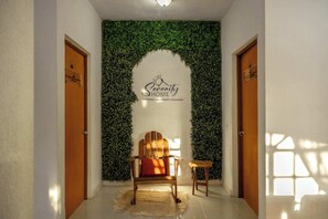 A hallway with a wooden chair, a small table, and a sign reading 'Serenity Home.' - Spacious House | 7 BR | Pool, Gym & Terrace (Mérida)