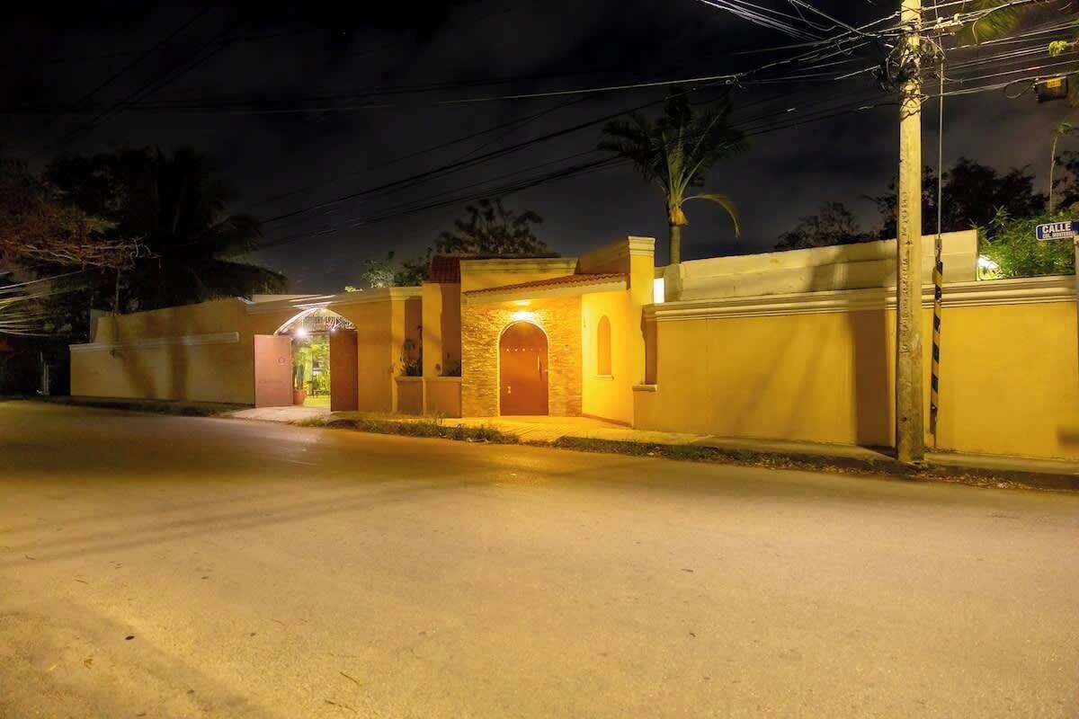 A residential building with a gated entrance, a small porch, and a well-lit front door.