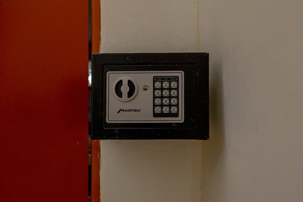A black security keypad lock mounted on a white wall.