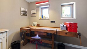 Un atelier équipé d’un établi, d’outils et de boîtes de rangement.