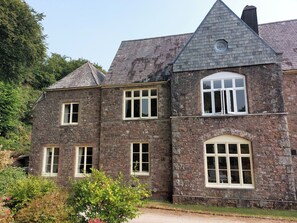 A stone building with multiple windows and a chimney. - Lukesland Wing (Ivybridge)