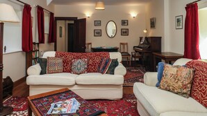 A living room with a sofa set, a coffee table, a piano, and a fireplace. - Lukesland Wing (Ivybridge)
