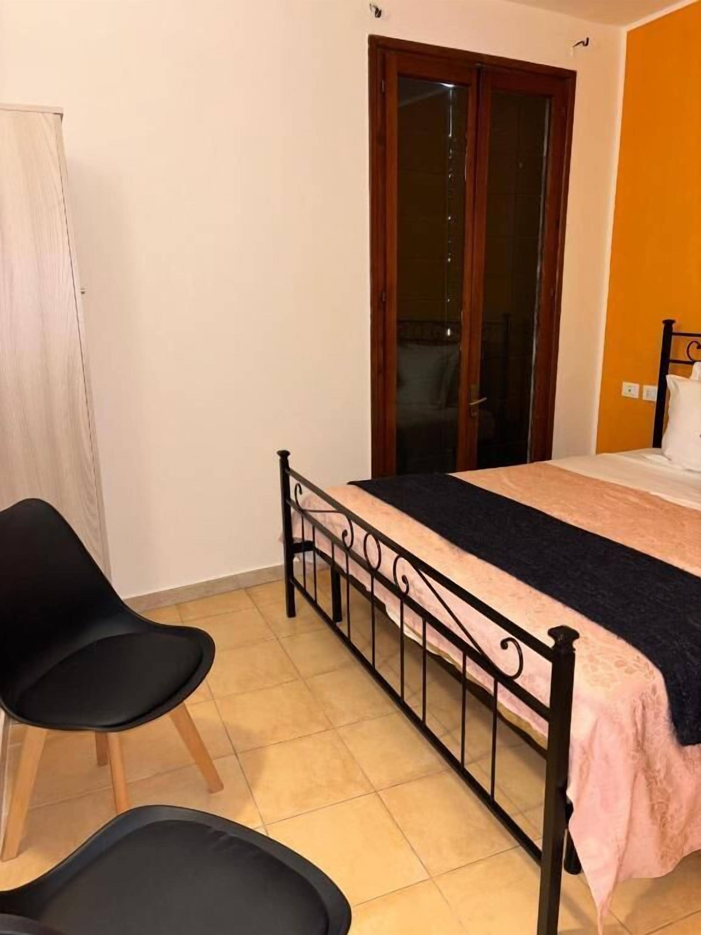 Une chambre à coucher avec un lit, une chaise, une armoire et une porte.