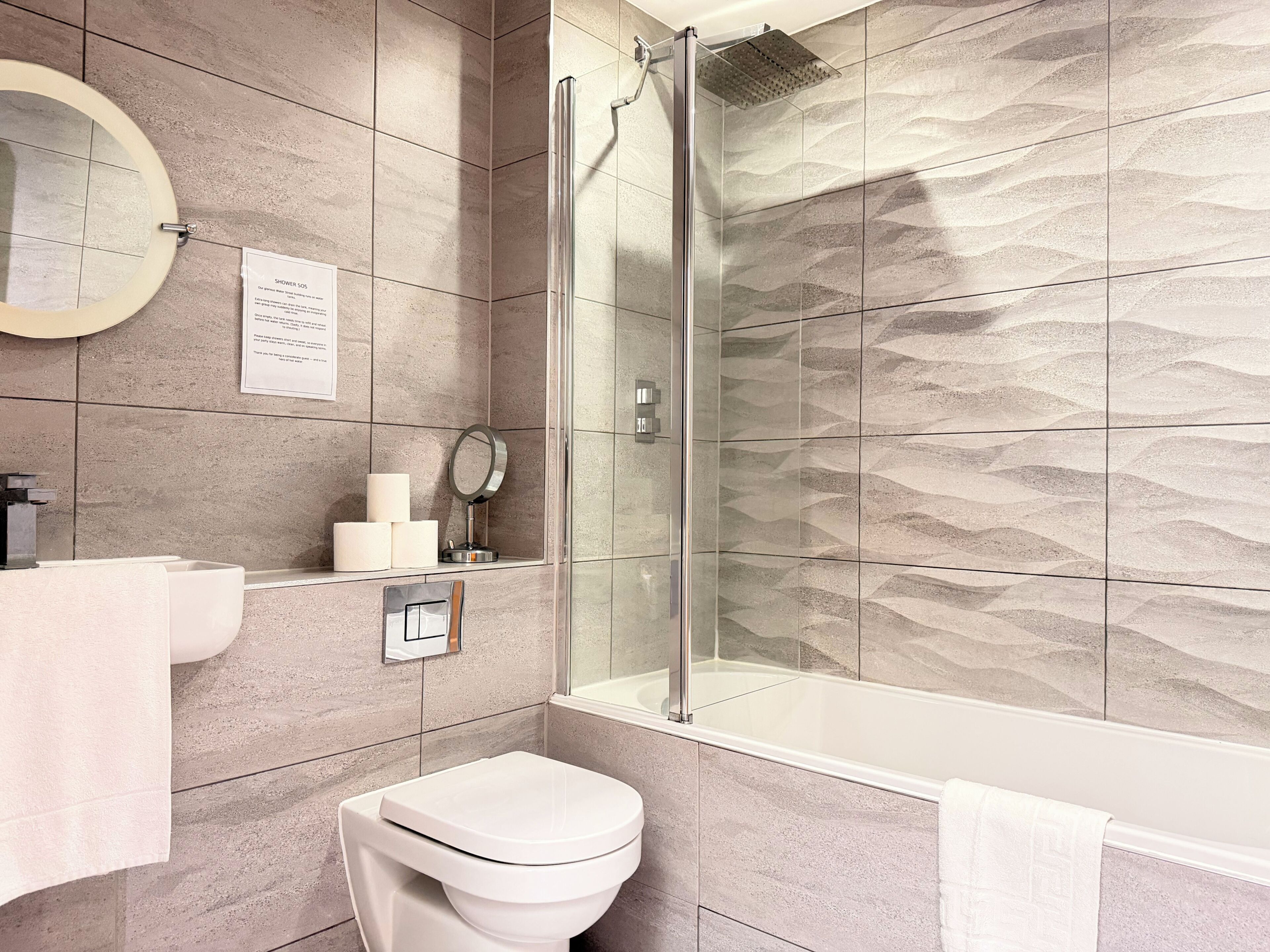 Une salle de bain moderne équipée d’une douche, de toilettes et d’un lavabo.