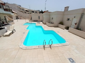 A swimming pool with two diving boards, a covered seating area, and a staircase leading to upper levels. - Amadores Paradise – Entire House (2 Connected Apartments) with the Complex's Pool (Mogán)