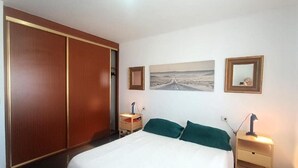 A bedroom with a bed, a nightstand, a lamp, a wardrobe, and a framed picture on the wall. - Amadores Paradise – Entire House (2 Connected Apartments) with the Complex's Pool (Mogán)