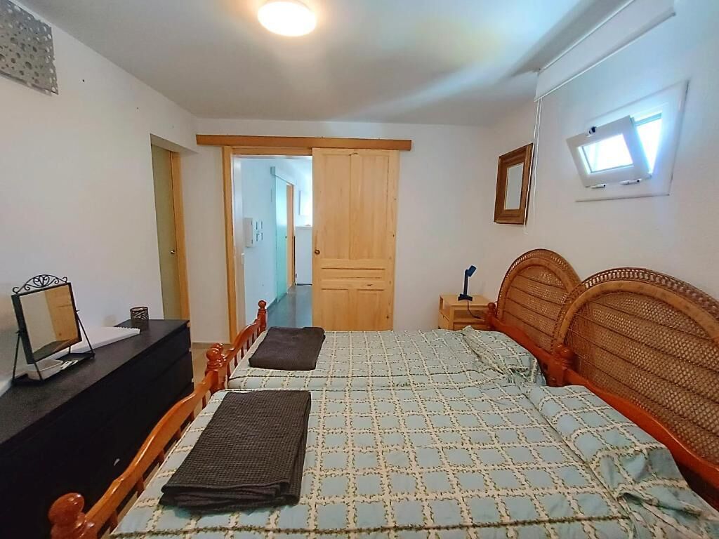 Une chambre à coucher avec un lit, une table de chevet et un miroir.
