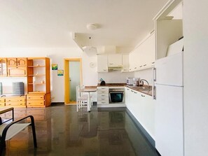 A modern kitchen with white cabinets, a built-in oven, and a dining area with a table and chairs. - Amadores Paradise – Entire House (2 Connected Apartments) with the Complex's Pool (Mogán)