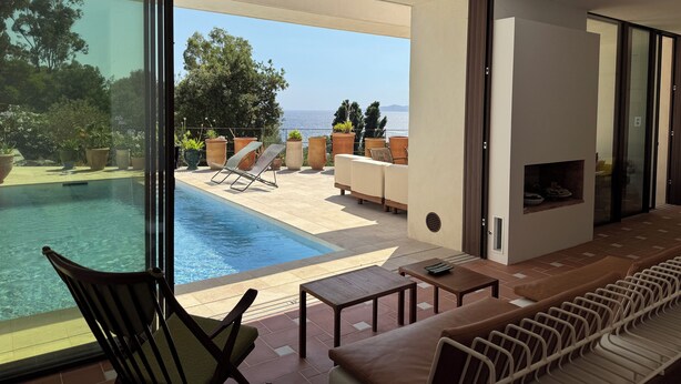 A modern living room with a pool, outdoor seating, and a view of the sea. - Architect-designed villa with a pool and a view of the Mediterranean – Sleeps 9 (Rayol-Canadel-sur-Mer)