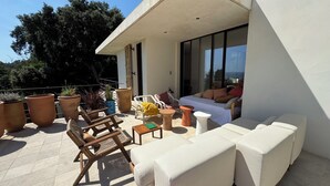 A modern outdoor seating area with a sofa, chairs, and potted plants. - Architect-designed villa with a pool and a view of the Mediterranean – Sleeps 9 (Rayol-Canadel-sur-Mer)