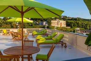 A rooftop terrace with wooden furniture, green cushions, and umbrellas. - Luxury Authentic Italian Villa with Private Pool & Iconic Seaview Terrace (Massa Lubrense)