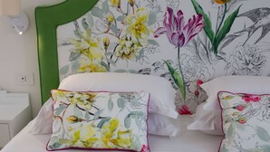 A bedroom with a green headboard, floral wallpaper, and two white beds with matching pillows. - Luxury Authentic Italian Villa with Private Pool & Iconic Seaview Terrace (Massa Lubrense)