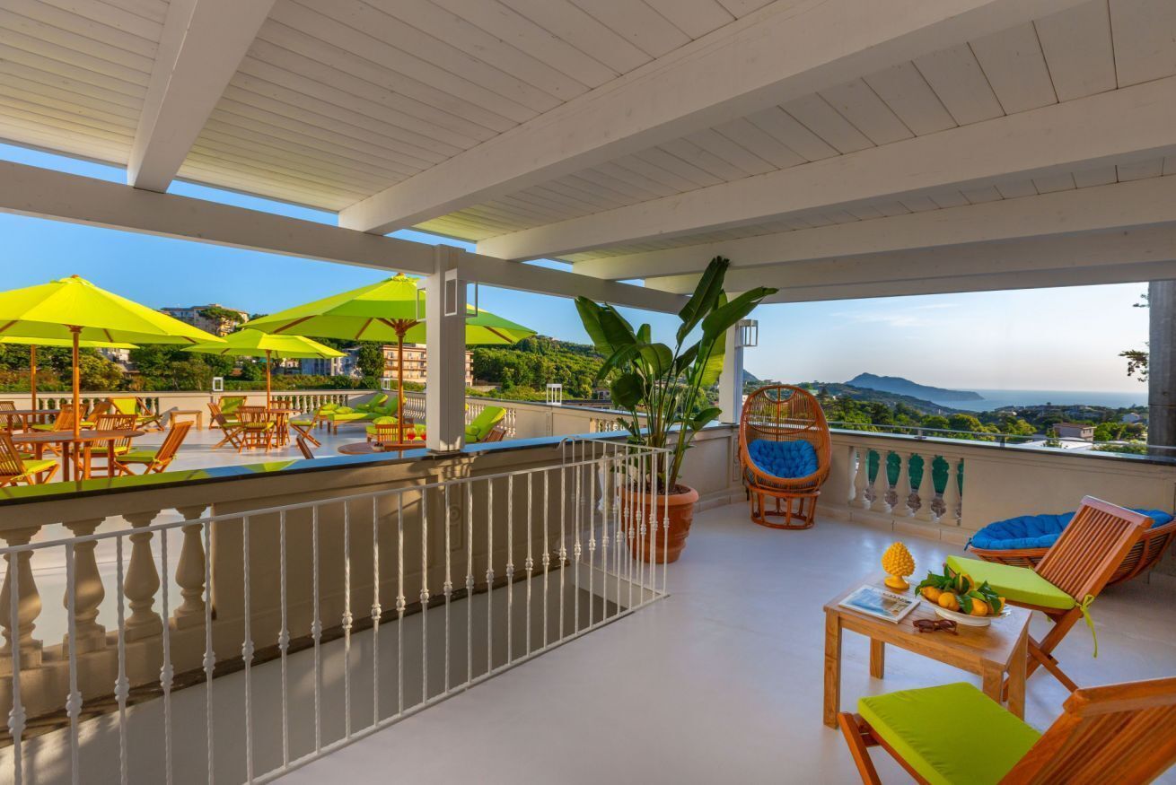 Una terraza con mobiliario exterior, sombrillas y vistas al paisaje.