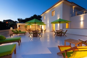 A rooftop terrace with lounge chairs, tables, and umbrellas. - Luxury Authentic Italian Villa with Private Pool & Iconic Seaview Terrace (Massa Lubrense)