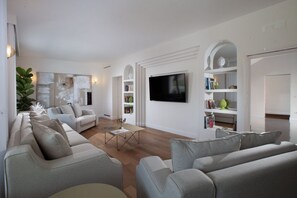 A modern living room with a sofa set, a coffee table, and a flat-screen TV mounted on the wall. - Luxury Authentic Italian Villa with Private Pool & Iconic Seaview Terrace (Massa Lubrense)