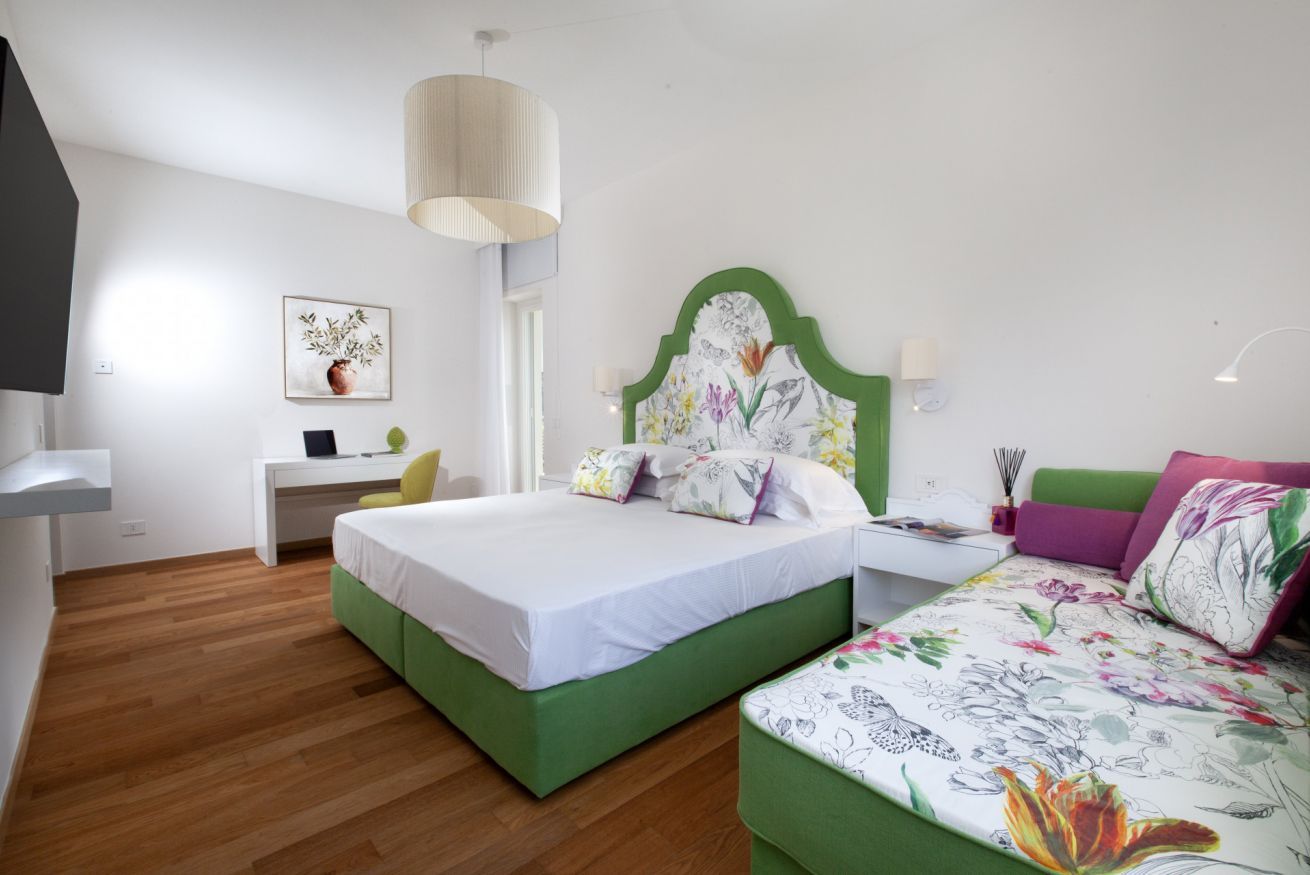 Une chambre à coucher comprenant un lit, une table de chevet, une lampe et un bureau avec une chaise.