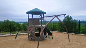 Ein Spielplatz mit Schaukeln und einer Kletterkonstruktion.