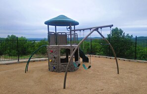 Ein Spielplatz mit Schaukeln und einer Kletterkonstruktion.