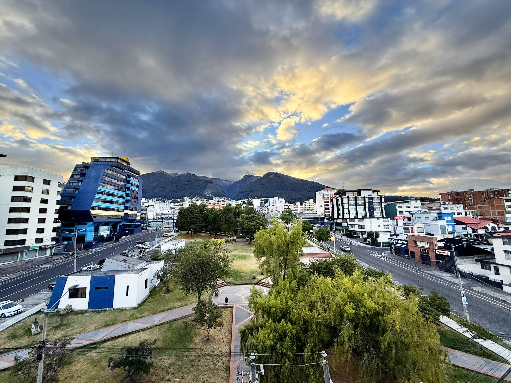 Paisagem urbana com edifícios modernos, uma estrada e uma área de parque.