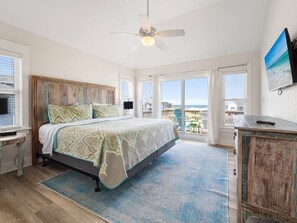 A bedroom with a bed, a ceiling fan, a view of the ocean, and a balcony. - Seabatical-4x4, Semi-Oceanfront w/ Pool & Hot Tub (Carolla)