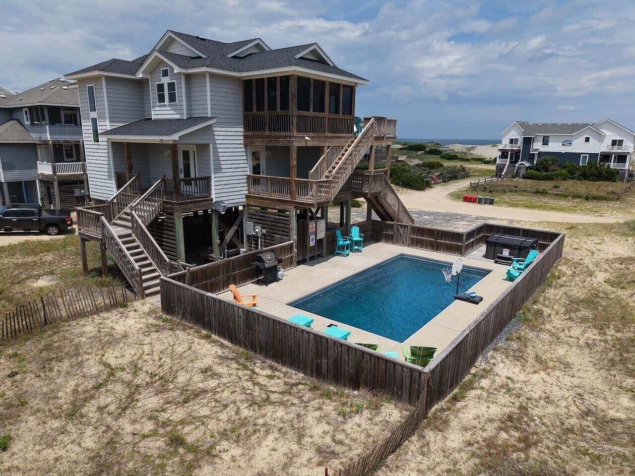 A two-story house with a deck and a swimming pool.