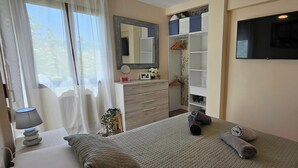 A bedroom with a bed, a dresser, a mirror, and a TV. - La Felicidad Apartment, Dénia, Next to the Beach (Dénia)