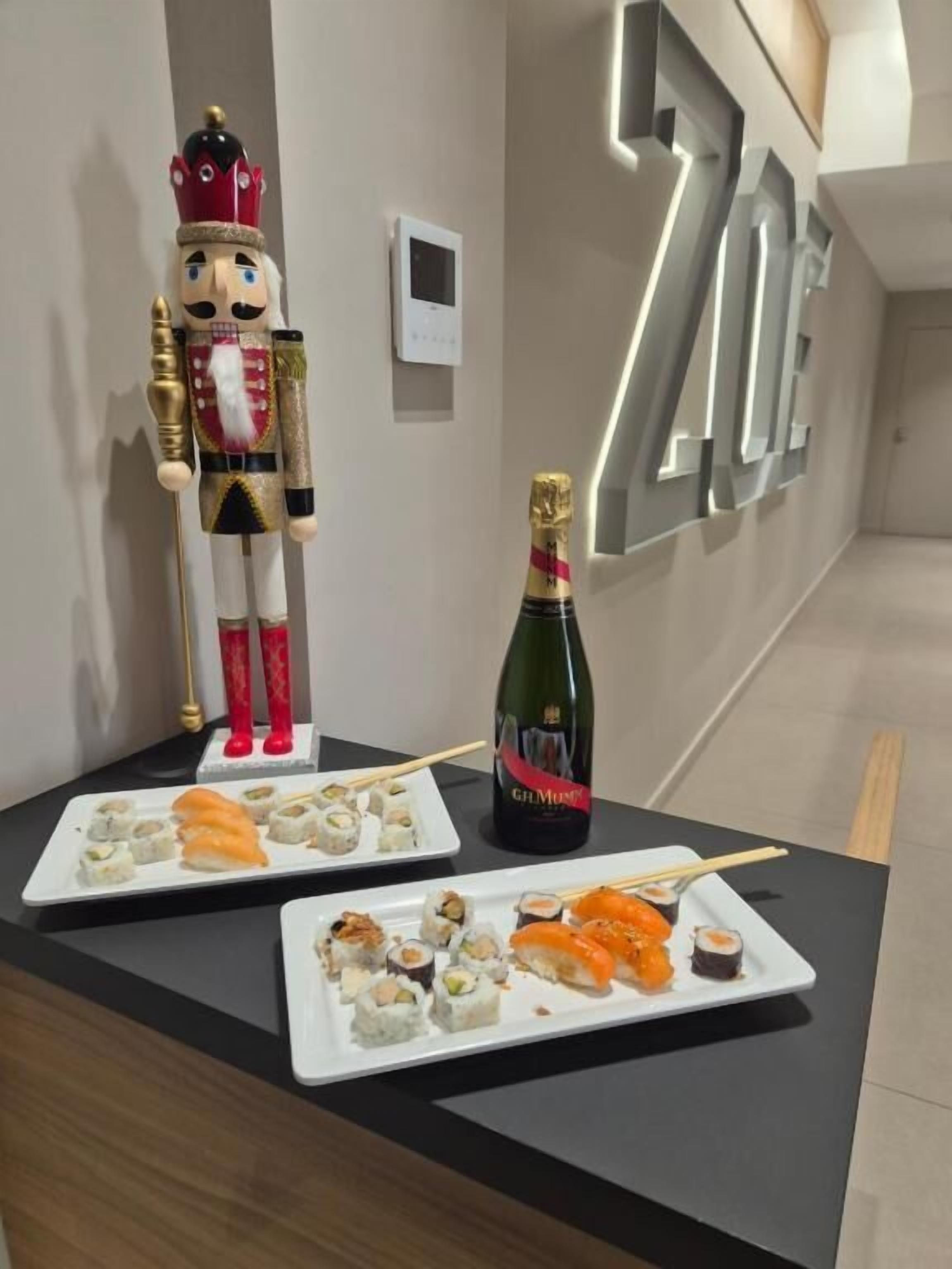 Ein Empfangsschalter mit Nussknacker, Sushi-Tellern und einer Champagnerflasche.