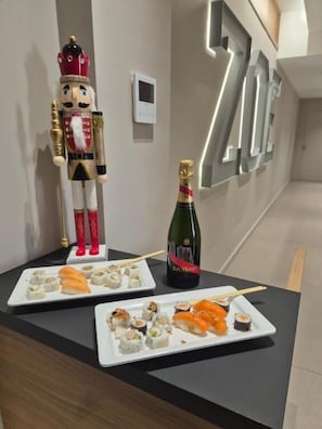 A reception desk with a nutcracker, sushi plates, and a champagne bottle. - Zoe luxury suites (Catania)