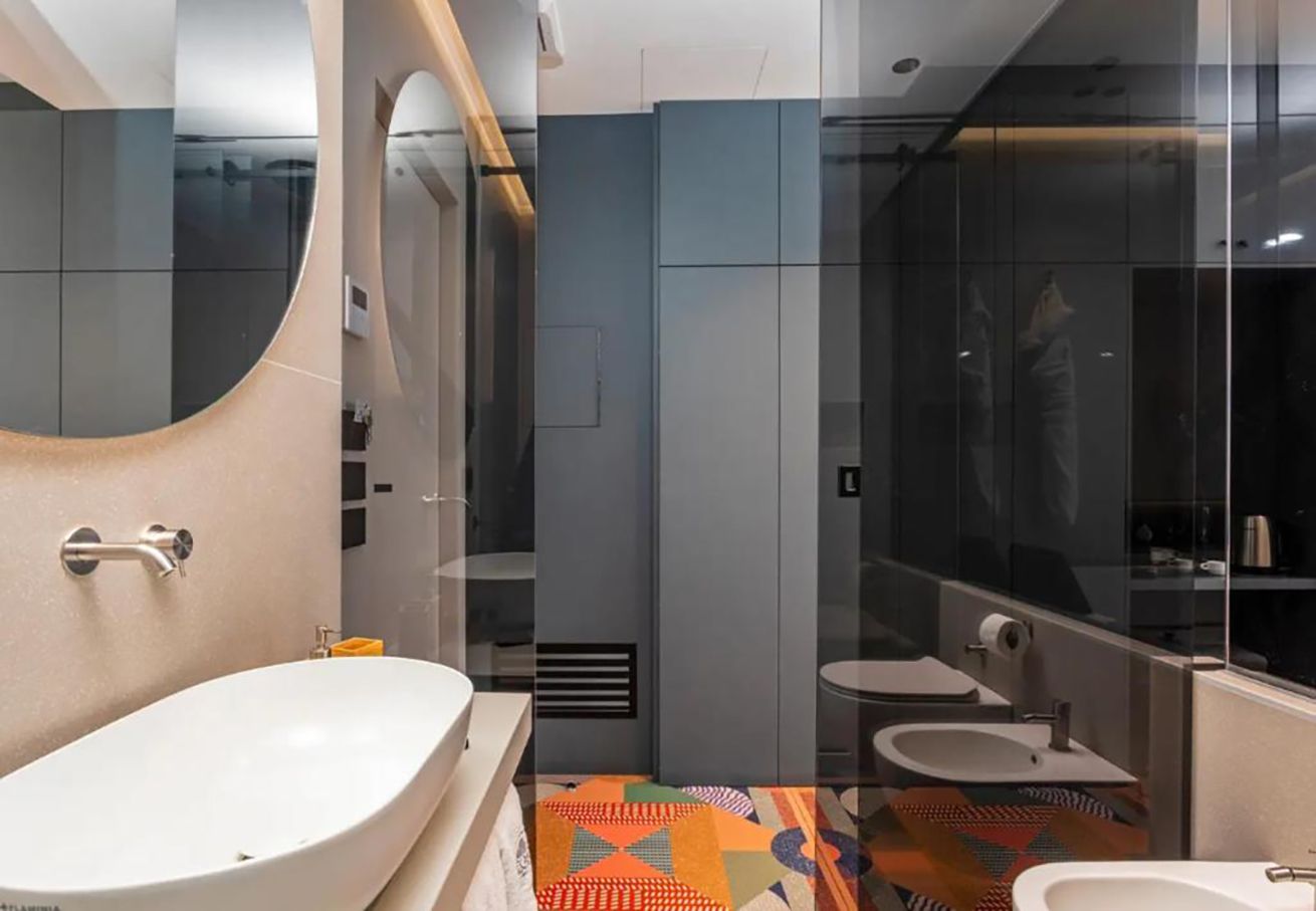 Une salle de bain moderne avec une grande baignoire, deux lavabos et un miroir.