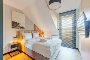 Camera da letto moderna con un letto, comodini, un abat-jour e un'opera d'arte appesa al muro, oltre a una finestra con persiane.