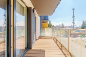 Un balcone con vista su auto parcheggiate e una torre di comunicazione.
