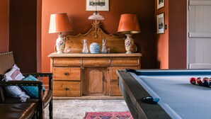 A room with a pool table, wooden cabinet with decorative items, and a framed picture on the wall. - Lavish Farmhouse With Lake Gardens Pool Table (Radstock)