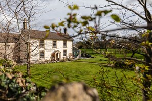 A large stone house with multiple windows and a well-maintained lawn. - Lavish Farmhouse With Lake Gardens Pool Table (Radstock)