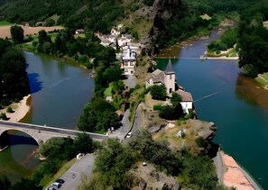 Ein Flussdorf mit einer markanten Kirche, einer Brücke und üppiger Vegetation.