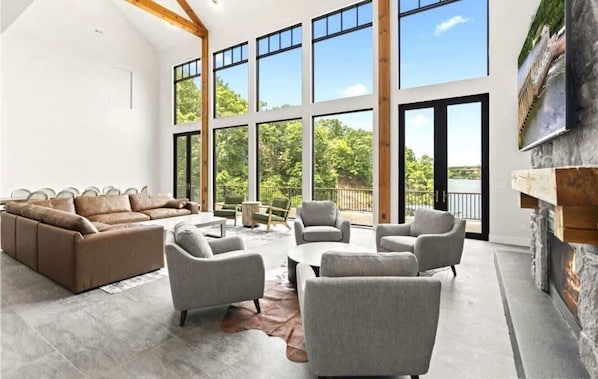 A spacious living area with a large window, a fireplace, and a sofa.