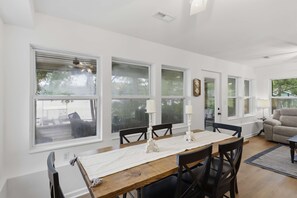 A dining area with a wooden table, white tablecloth, and candle holders. - Visit This 4 Bedroom - 3 Bath Lakefront Home With Private Dock (Stover)