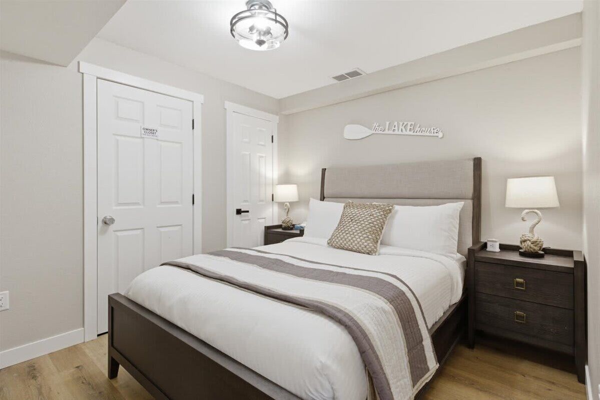A bedroom with a bed, two bedside tables, a wall-mounted sign, and a door labeled 'OWNER'S CLOSE'.