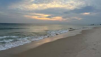 A beach with a wide sandy shore and gentle waves.