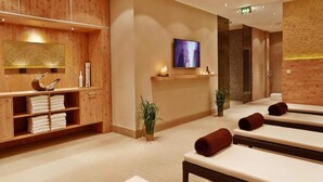 A spa room with wooden paneling, a television, and multiple massage tables. - 2 Person Holiday Park Home in Hannover (Hannover)