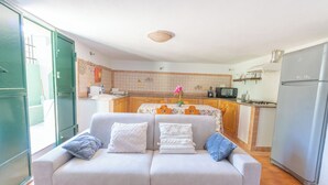 A modern kitchen with a sofa in the foreground, a microwave, and a refrigerator.