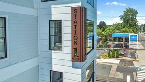 A hotel named 'Station 1' with a clear view of the street and a gas station in the background. - Station 1 Hotel #3 (Stonington)