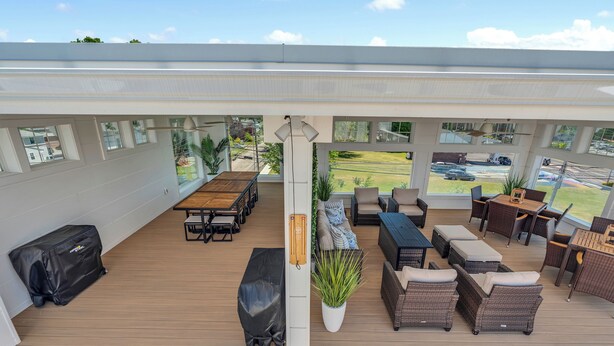 An outdoor deck with a covered seating area, a grill, and a potted plant. - Station 1 Hotel #3 (Stonington)