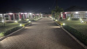 Ein Weg, der zu einer Reihe gut beleuchteter Gebäude führt, vermutlich Teil eines Hotels oder Resorts.