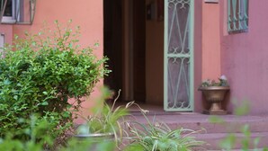 A building with a pink facade, a green door, and potted plants. - Cozy 1-bedroom studio in beautiful Marrakech with AC (Marrakech)