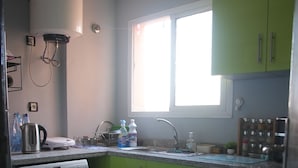 A compact kitchen with a washing machine, a window, and a sink. - Cozy 1-bedroom studio in beautiful Marrakech with AC (Marrakech)