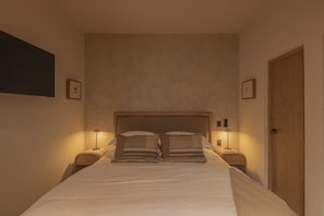 A bedroom with a large bed, two bedside tables with lamps, a wooden door, and framed pictures on the walls. - NEW Beautiful loft - KS bed - A/C Roma Norte (Ciudad de México)