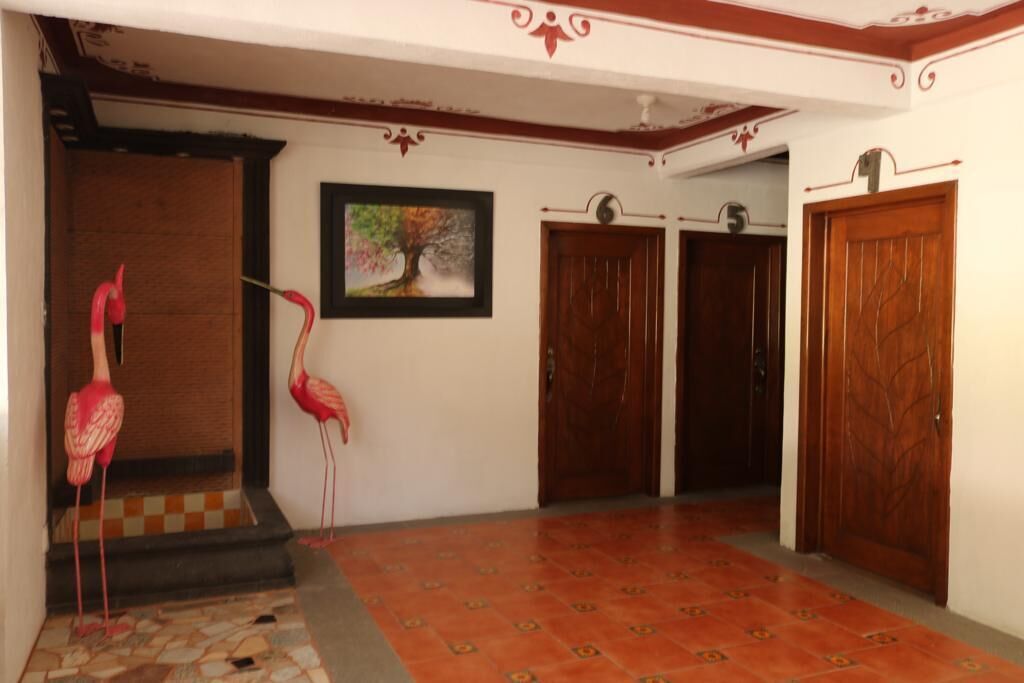 A hallway with a tiled floor, wooden doors, and a framed picture on the wall.