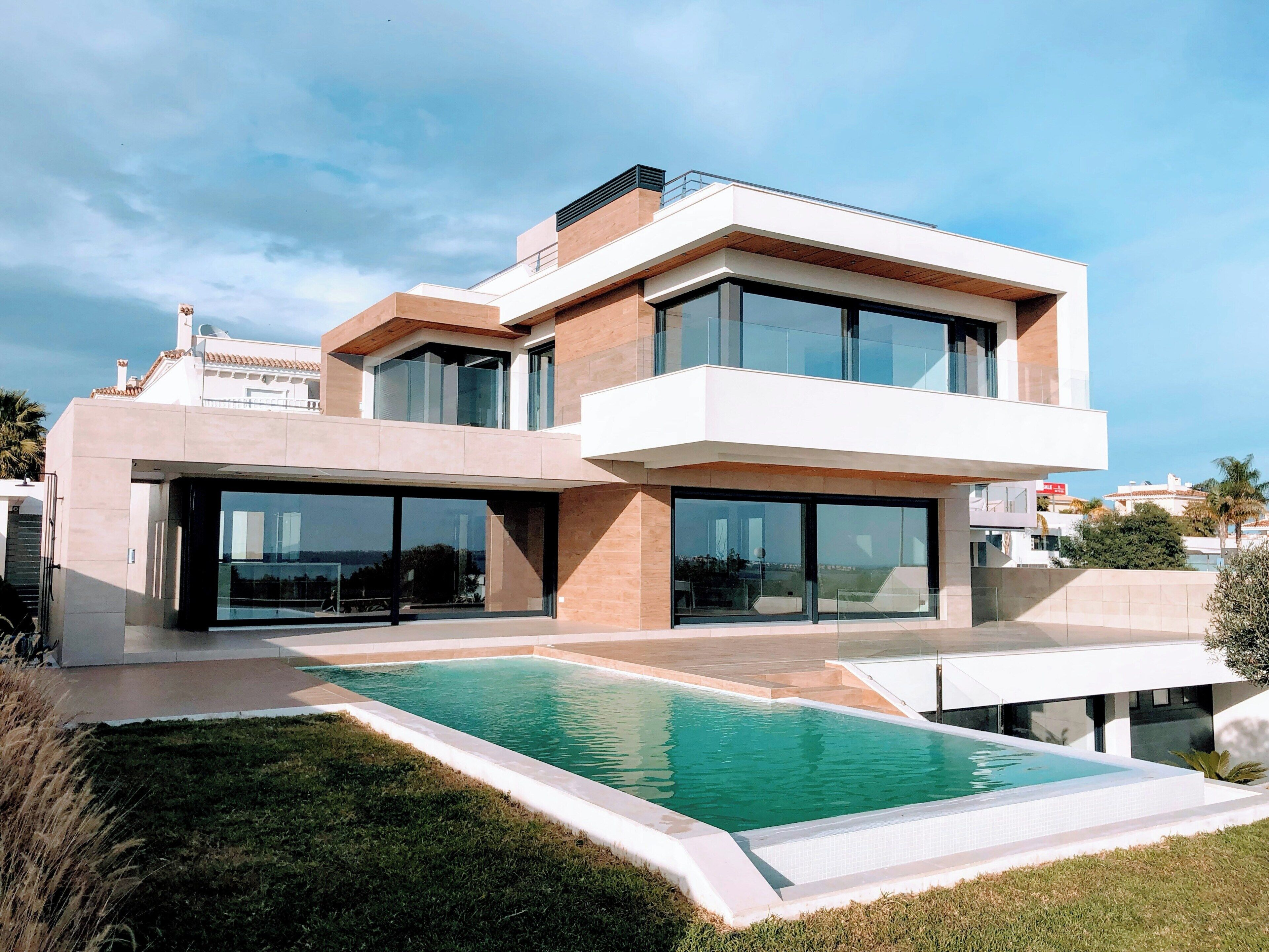 A modern two-story house with a swimming pool in the front yard.