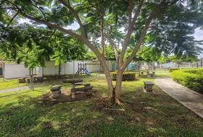 A fenced outdoor area with a picnic table, a bench, and a playground. - Acogedora Casa de Playa, Condominio Malaga Bejuco (Parrita)